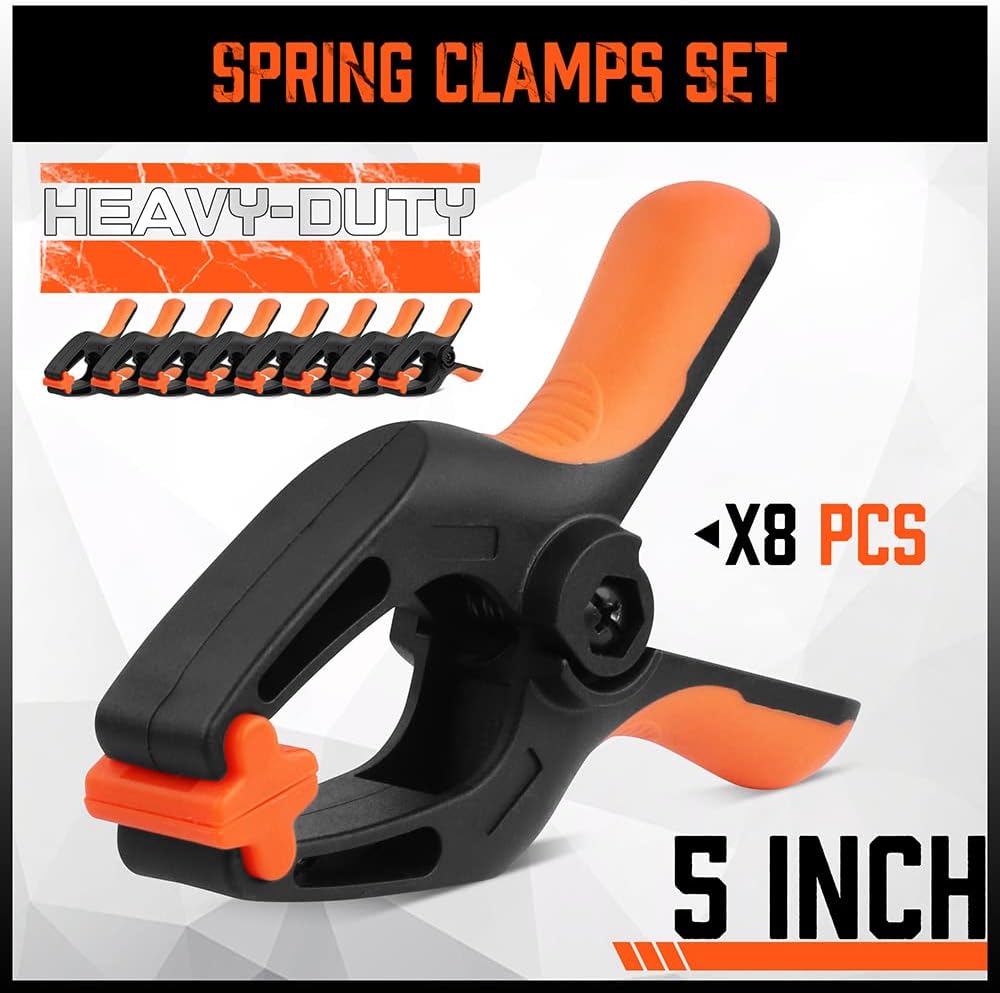 Heavy duty 5-inch orange and black spring clamps with flexible jaw pads and ergonomic handles for woodworking, DIY, and backdrop support