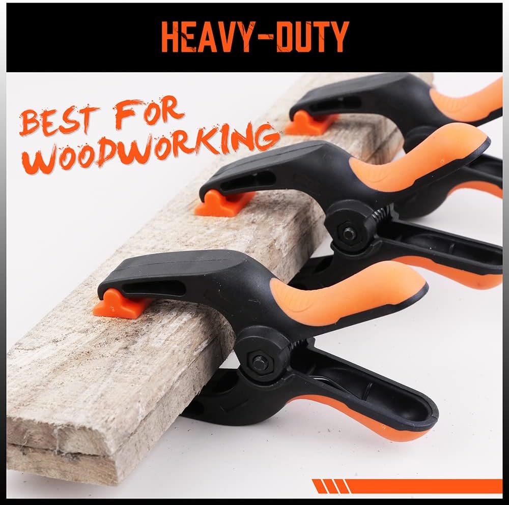 Heavy duty 5-inch orange and black spring clamps with flexible jaw pads and ergonomic handles for woodworking, DIY, and backdrop support